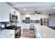 Modern kitchen with stainless steel appliances, white cabinets, quartz countertop, and stylish backsplash at 127 Holly St, Social Circle, GA 30025