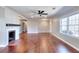 Well-lit living area featuring hardwood floors, large window, and fireplace with wood mantle at 127 Holly St, Social Circle, GA 30025