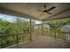 Relaxing covered patio with wooden deck flooring and views of surrounding trees and neighborhood at 203 Retreat Ln, Canton, GA 30114