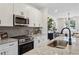 Updated kitchen featuring stainless steel appliances, gray backsplash, and an island overlooking the living space at 310 Mcdonough Se Blvd # 104, Atlanta, GA 30315