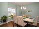 Well-lit dining room features a modern chandelier, lovely wall decor, and a faux marble-topped table at 2101 Slick Stone Dr, Snellville, GA 30078