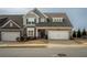 Charming brick-accented townhome with a two-car garage, American flag, and well-maintained landscaping at 2101 Slick Stone Dr, Snellville, GA 30078