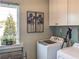 Bright laundry room features white cabinets, a large window, and modern appliances at 2101 Slick Stone Dr, Snellville, GA 30078