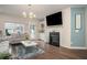 Cozy living room with a fireplace, mounted TV, and plenty of natural light at 2101 Slick Stone Dr, Snellville, GA 30078