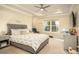 Spacious primary bedroom features a tray ceiling, ceiling fan, and a large window for natural light at 2101 Slick Stone Dr, Snellville, GA 30078