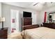 Bright bedroom features hardwood floors, television, and view of adjoining bathroom at 2057 Bixler Cir, Decatur, GA 30032
