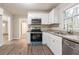 Modern kitchen featuring sleek white cabinetry, stainless steel appliances, and elegant granite countertops, with updated flooring at 3527 Glenview Sw Cir, Atlanta, GA 30331