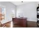 Well-lit home office featuring a large desk, hardwood floors, and windows overlooking a backyard at 569 Hope Sw St, Atlanta, GA 30310