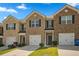 Charming brick townhome featuring a one-car garage, manicured lawn, and inviting front entrance at 815 Taurus Dr, Stockbridge, GA 30281