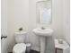 Cozy half bathroom with pedestal sink, toilet, and neutral decor, conveniently located for guests at 815 Taurus Dr, Stockbridge, GA 30281