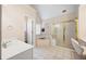 Bright bathroom featuring a soaking tub, glass enclosed shower and neutral tile flooring at 130 Brookridge Ct, Fayetteville, GA 30215