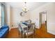 Charming dining room with hardwood floors, a modern chandelier, and a blue accent bench at 130 Brookridge Ct, Fayetteville, GA 30215