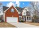 Side view of a two-story brick home with a two-car garage and front porch at 130 Brookridge Ct, Fayetteville, GA 30215