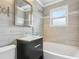 Stylish bathroom with a glass bowl sink, elegant mirror, and tiled walls at 2184 Clairmont Ne Ter, Atlanta, GA 30345