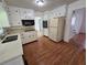 Well-lit kitchen featuring wood floors, white cabinets, and modern appliances at 3240 Corktree Trl, Lithonia, GA 30038