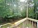 Elevated view of the wooded backyard from the deck with railing at 525 S Lost Lake Cv, Villa Rica, GA 30180