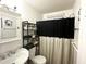 Cozy bathroom with neutral decor, patterned shower curtain, and corner shelving at 525 S Lost Lake Cv, Villa Rica, GA 30180