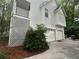 Rear exterior featuring a three-car garage and partial latticework at 525 S Lost Lake Cv, Villa Rica, GA 30180