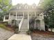 Charming two-story home featuring a welcoming front porch with stairs and manicured shrubs and trees at 525 S Lost Lake Cv, Villa Rica, GA 30180