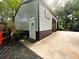 View of the two-tone garage with an American Flag, flower pots, and a concrete driveway at 525 S Lost Lake Cv, Villa Rica, GA 30180