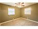 This bedroom features neutral walls, carpet floors, a ceiling fan and two windows to let in natural light at 285 Argus Nw Cir, Atlanta, GA 30331