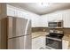 Close-up of kitchen featuring stainless steel appliances, granite countertops, and bright white cabinets at 285 Argus Nw Cir, Atlanta, GA 30331