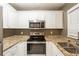 A bright kitchen featuring granite countertops, stainless steel appliances, and white cabinets at 285 Argus Nw Cir, Atlanta, GA 30331