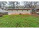 View of the backyard with green space and the rear of the brick home at 3111 Flat Shoals Rd, Decatur, GA 30034