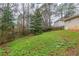 The sloped backyard is fenced in and has large trees surrounding the perimeter at 3111 Flat Shoals Rd, Decatur, GA 30034