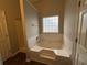 Bathroom with a large soaking tub under a window and separate shower at 4976 Notting Glen Ln, Snellville, GA 30039