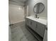 Updated bathroom featuring modern vanity, round mirror, shower and tub combination, and tile floors at 4976 Notting Glen Ln, Snellville, GA 30039