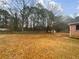 Large backyard with a wooden fence, mature trees, and ample space for outdoor activities and landscaping at 180 Antebellum Way, Fayetteville, GA 30215