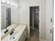 Bathroom featuring neutral cabinets, large mirror, vanity lights, and a tile floor at 180 Antebellum Way, Fayetteville, GA 30215