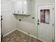 Well-lit laundry room with white cabinets and an exterior door at 180 Antebellum Way, Fayetteville, GA 30215