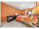 Bright bedroom featuring orange walls, carpeted floor, and a comfortable bed with patterned bedding at 854 Malvern Blvd, Stone Mountain, GA 30087