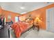 Cozy bedroom features orange walls and a comfortable bed with orange and floral bedding, creating a warm and inviting space at 854 Malvern Blvd, Stone Mountain, GA 30087