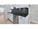 Updated kitchen features white cabinets, stainless steel appliances, granite countertops, and a stylish black backsplash at 1160 Windsor Pkwy # 13, Atlanta, GA 30319
