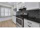 Well-lit kitchen featuring stainless steel appliances, subway tile backsplash, granite counters, and wood floors at 1160 Windsor Pkwy # 13, Atlanta, GA 30319