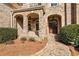 Charming front entrance with stone archways, a wooden door, and manicured landscaping at 3030 Creek Tree Ln, Cumming, GA 30041