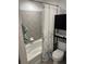 Clean bathroom featuring a tiled tub and a shower with floral shower curtain at 361 17Th Nw St # 2308, Atlanta, GA 30363