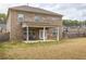 Backyard of a two-story brick house with a covered patio and a well-maintained lawn at 600 Lockerbie Ter, Mcdonough, GA 30252