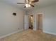Bedroom with neutral carpet, ceiling fan, and open doorways at 600 Lockerbie Ter, Mcdonough, GA 30252