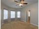 Bedroom with bay window featuring light-filled windows with floral curtains, and a ceiling fan at 600 Lockerbie Ter, Mcdonough, GA 30252