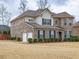 Two-story brick home with a turret, two-car garage, and manicured lawn at 600 Lockerbie Ter, Mcdonough, GA 30252