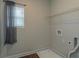 Bright laundry room features a window, shelving, and utility connections at 600 Lockerbie Ter, Mcdonough, GA 30252