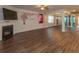 Open-concept living room with hardwood floors, fireplace, TV, and decorative wall art at 600 Lockerbie Ter, Mcdonough, GA 30252