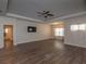 A large open living room includes tray ceilings, fan, modern flooring and natural light at 600 Lockerbie Ter, Mcdonough, GA 30252