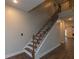 Carpeted staircase with wrought iron banister and hardwood floors at 600 Lockerbie Ter, Mcdonough, GA 30252