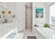 Bright bathroom featuring a soaking tub, walk-in shower, and a large window for plenty of natural light at 1137 Maple Creek Rdg, Loganville, GA 30052