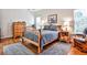 Cozy bedroom features hardwood floors, a wooden bed frame, and large windows for plenty of natural light at 1137 Maple Creek Rdg, Loganville, GA 30052